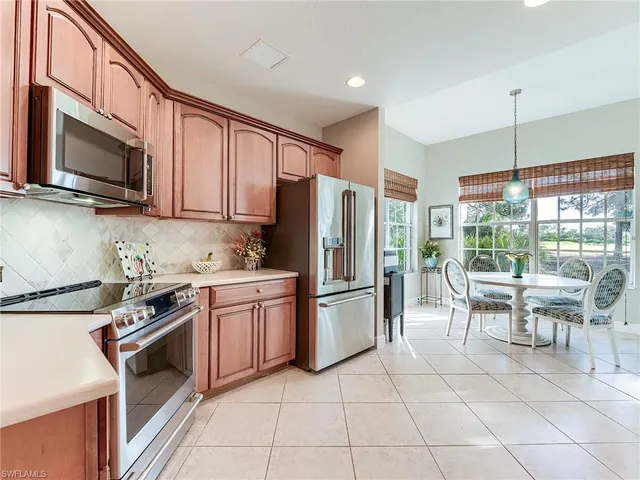 a kitchen with stainless steel appliances granite countertop a stove top oven a refrigerator a sink and a granite counter tops