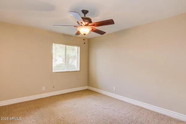 an empty room with a window and a fan