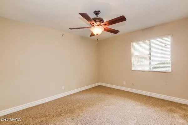 an empty room with a window and a fan