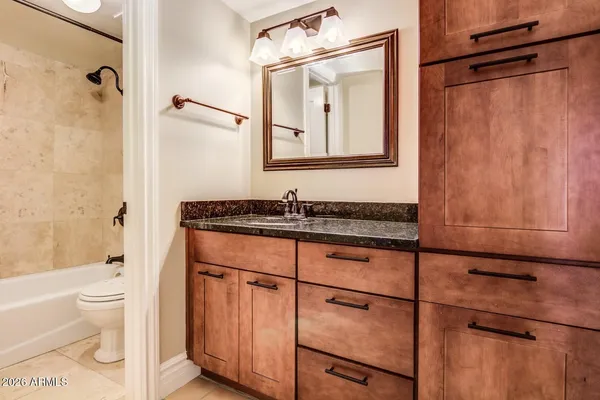 a bathroom with a granite countertop sink toilet and shower