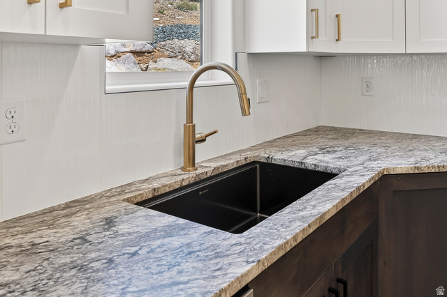 2862 South Mountain Rnch Road Cedar City, UT 84720 - Photo 18 of 64 Corner kitchen sink with a gold-tone gooseneck faucet, set into a stone countertop