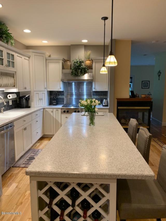 19 State Line Road West Stockbridge, MA 01266 - Photo 16 of 45 a kitchen with stainless steel appliances granite countertop a stove a refrigerator a sink a dining table and chairs with wooden floor