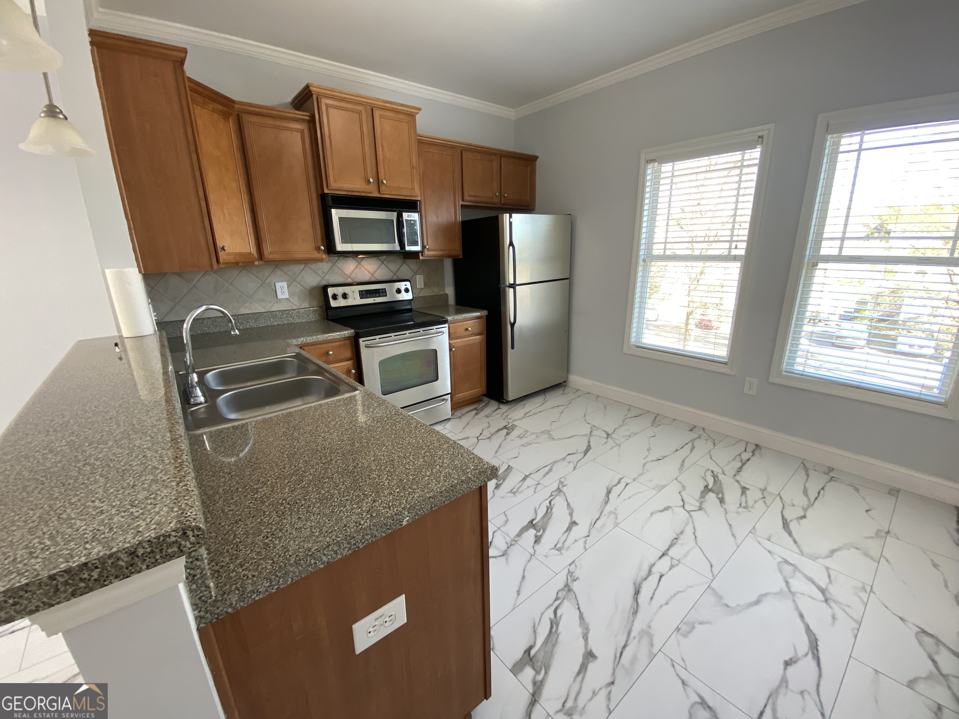 417 Whitehall Road Athens, GA 30605 - Photo 57 of 72 a kitchen with granite countertop a refrigerator stove and microwave