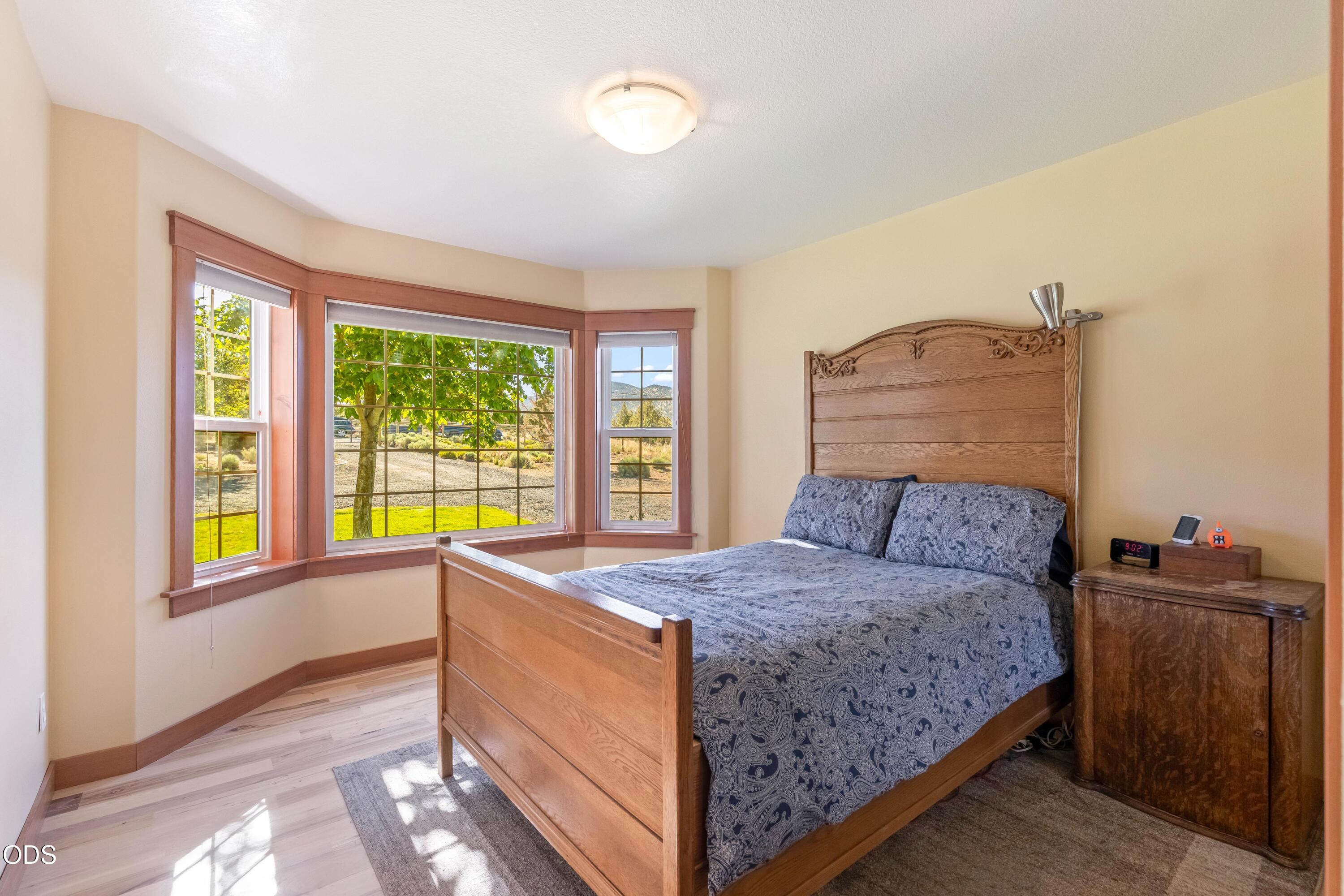 13753 South Sego Lily Road Powell Butte, OR 97753 - Photo 13 of 46 a bedroom with a bed and a large window