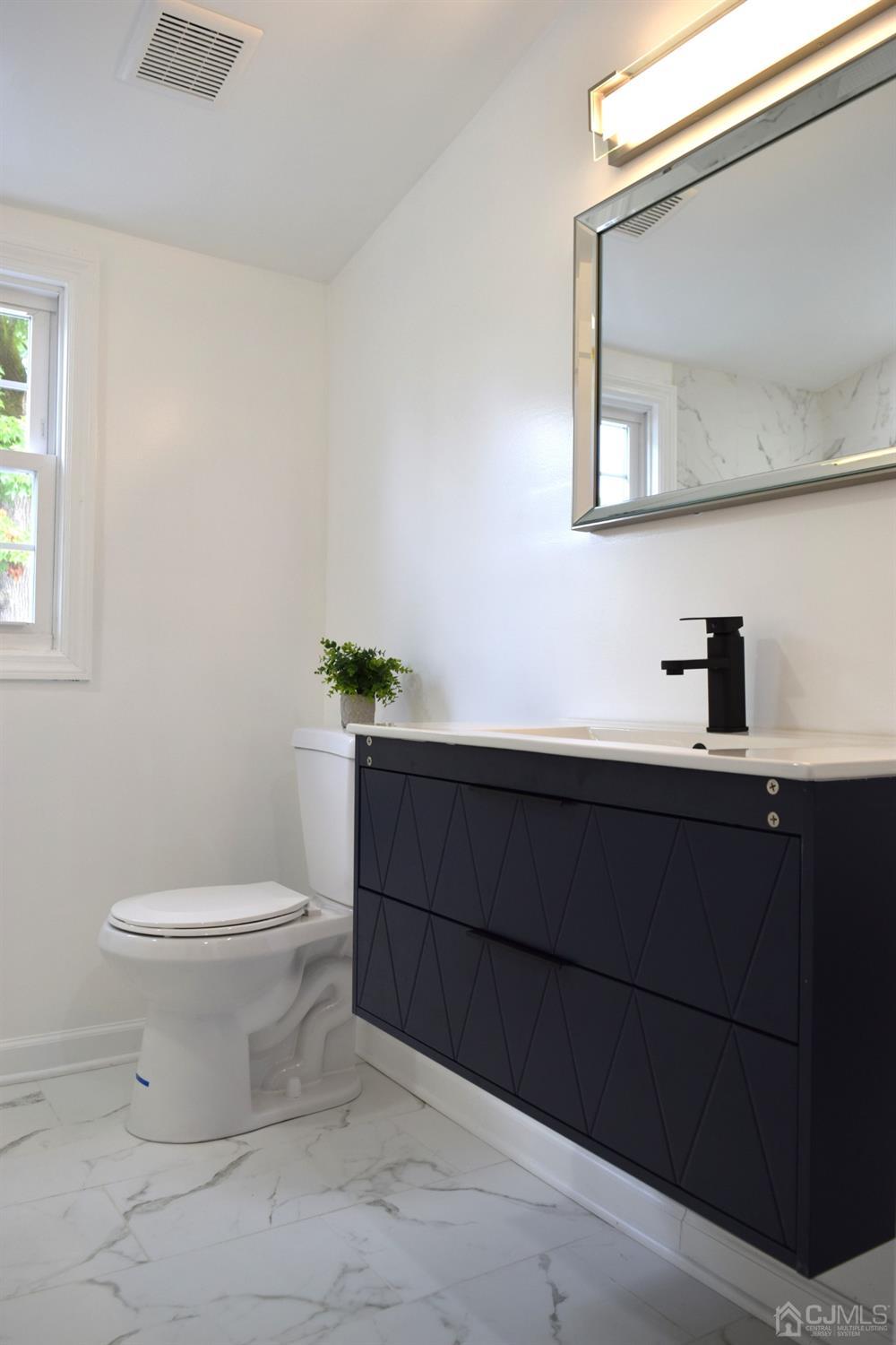42 West Cliff Road Colonia, NJ 07067 - Photo 10 of 14 a bathroom with a toilet a sink and mirror