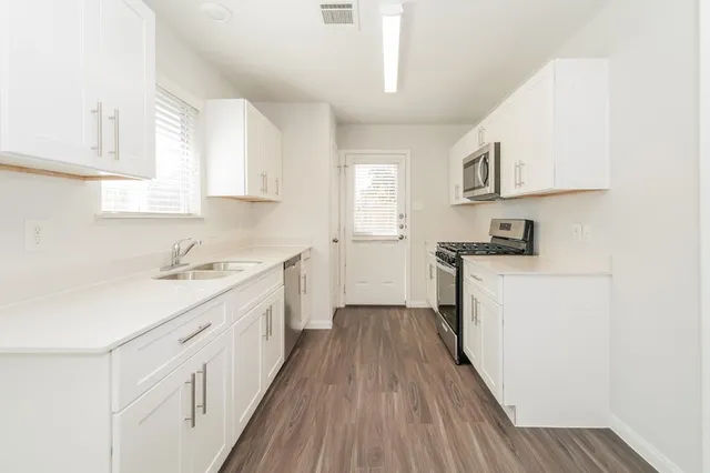 a kitchen with cabinets a sink and wooden floor