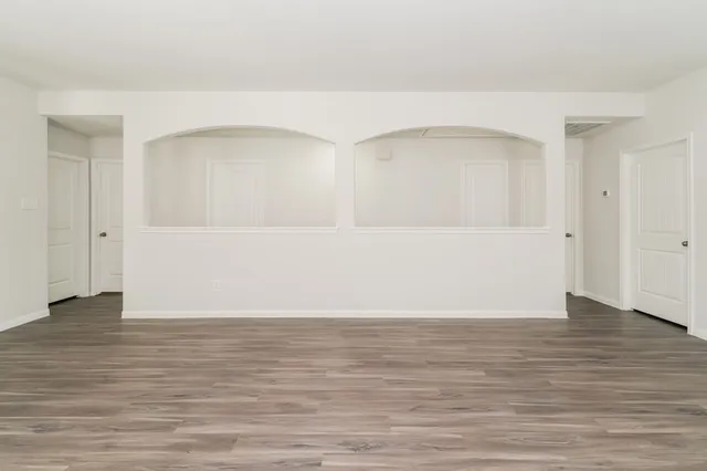 a view of an empty room with wooden floor