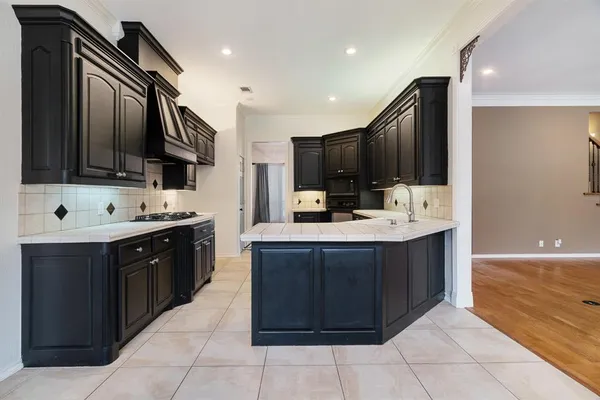 a large kitchen with kitchen island granite countertop a sink and dishwasher a oven with wooden cabinets