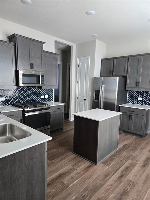 4907 Escape Rivera Drive Austin, TX 78747 - Photo 5 of 28 Modern kitchen with sleek cabinetry, a central island, and contemporary stainless steel appliances.