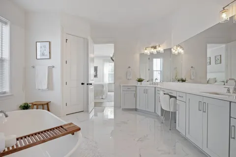 a view of a livingroom with wooden floor entryway and a couch