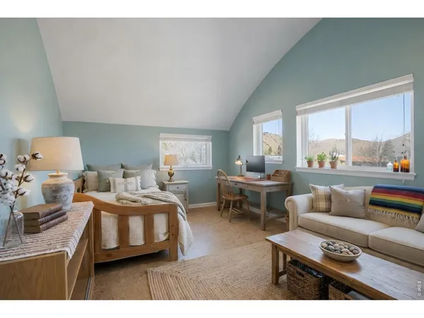 a bedroom with furniture and a large window
