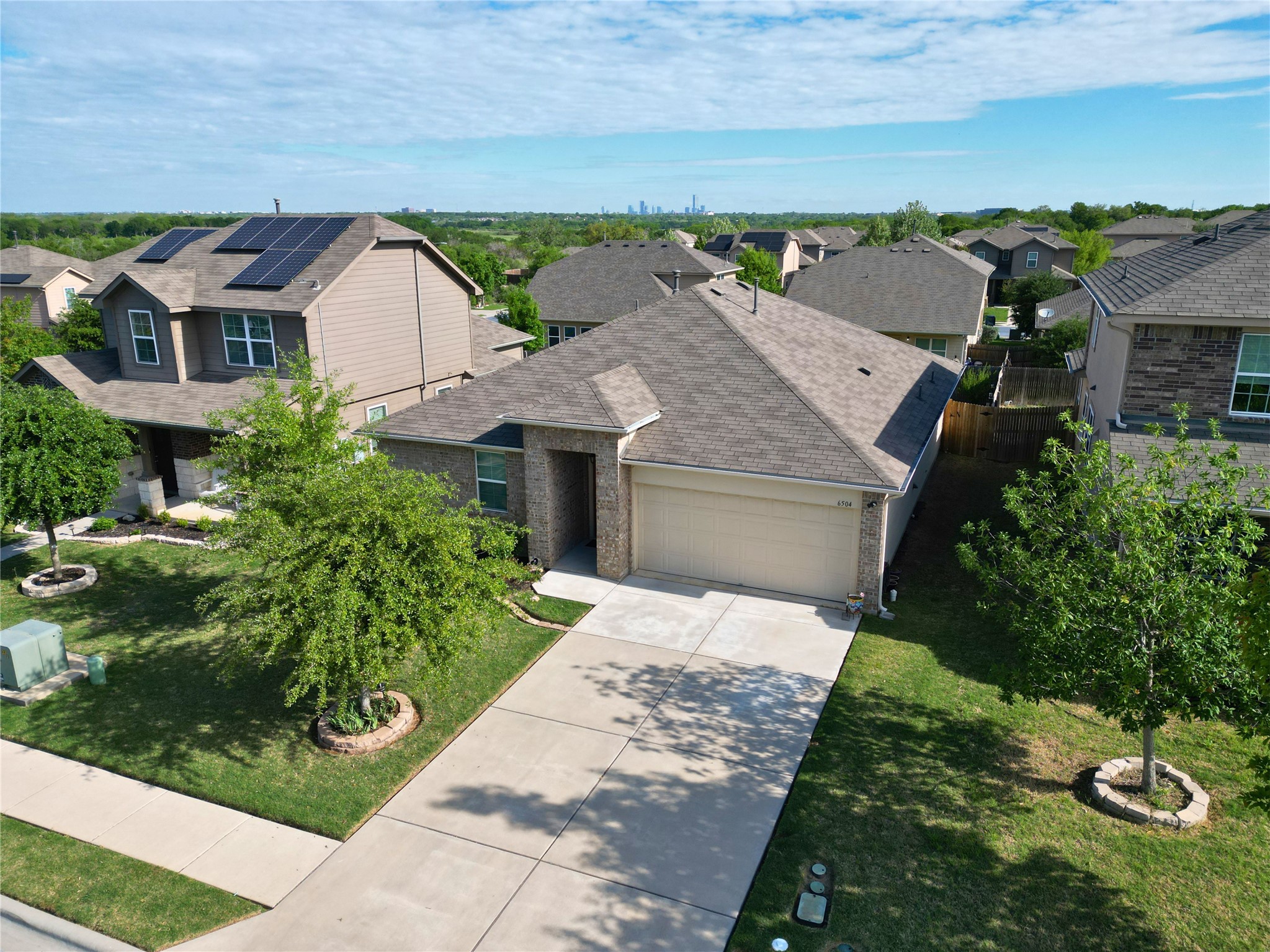 6504 Ranchito Drive Austin, TX 78744 - Photo 1 of 1 Traditional home featuring a garage, driveway, roof with shingles, a residential view, and a front lawn