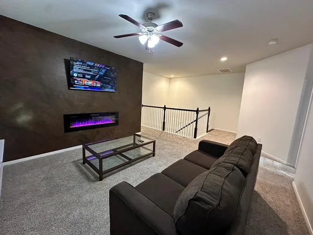 a living room with furniture and a ceiling fan
