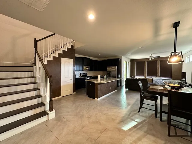 a kitchen with stainless steel appliances kitchen island granite countertop a sink and a refrigerator