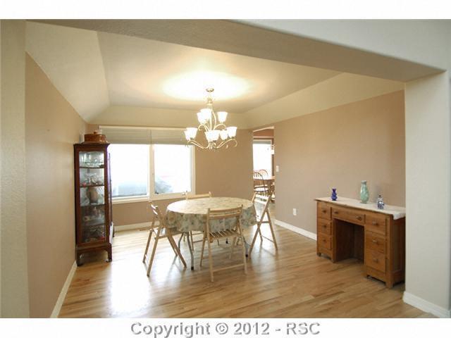 17710 New London Road Monument, CO 80132 - Photo 10 of 15 Dining room with hardwood floor and coffered ceiling. That window looks to the west - views to dine by!