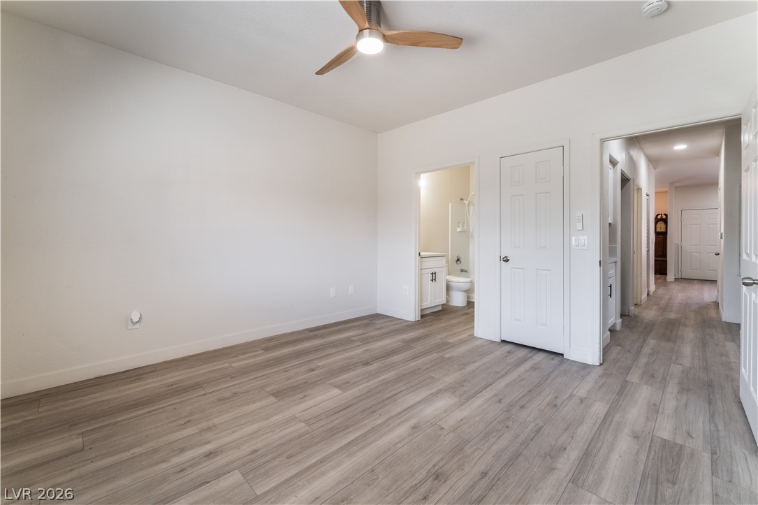 4730 East Craig Road, Unit 1058 Las Vegas, NV 89115 - Photo 16 of 30 A well-lit primary bedroom featuring durable wood-look flooring and a modern ceiling fan for comfort.