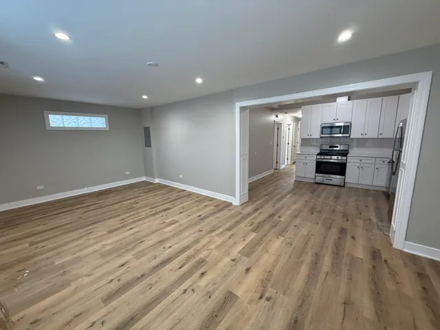 a view of empty room with wooden floor