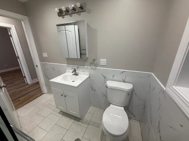 a bathroom with a sink toilet and mirror