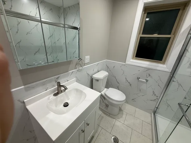 a bathroom with a sink and glass door shower
