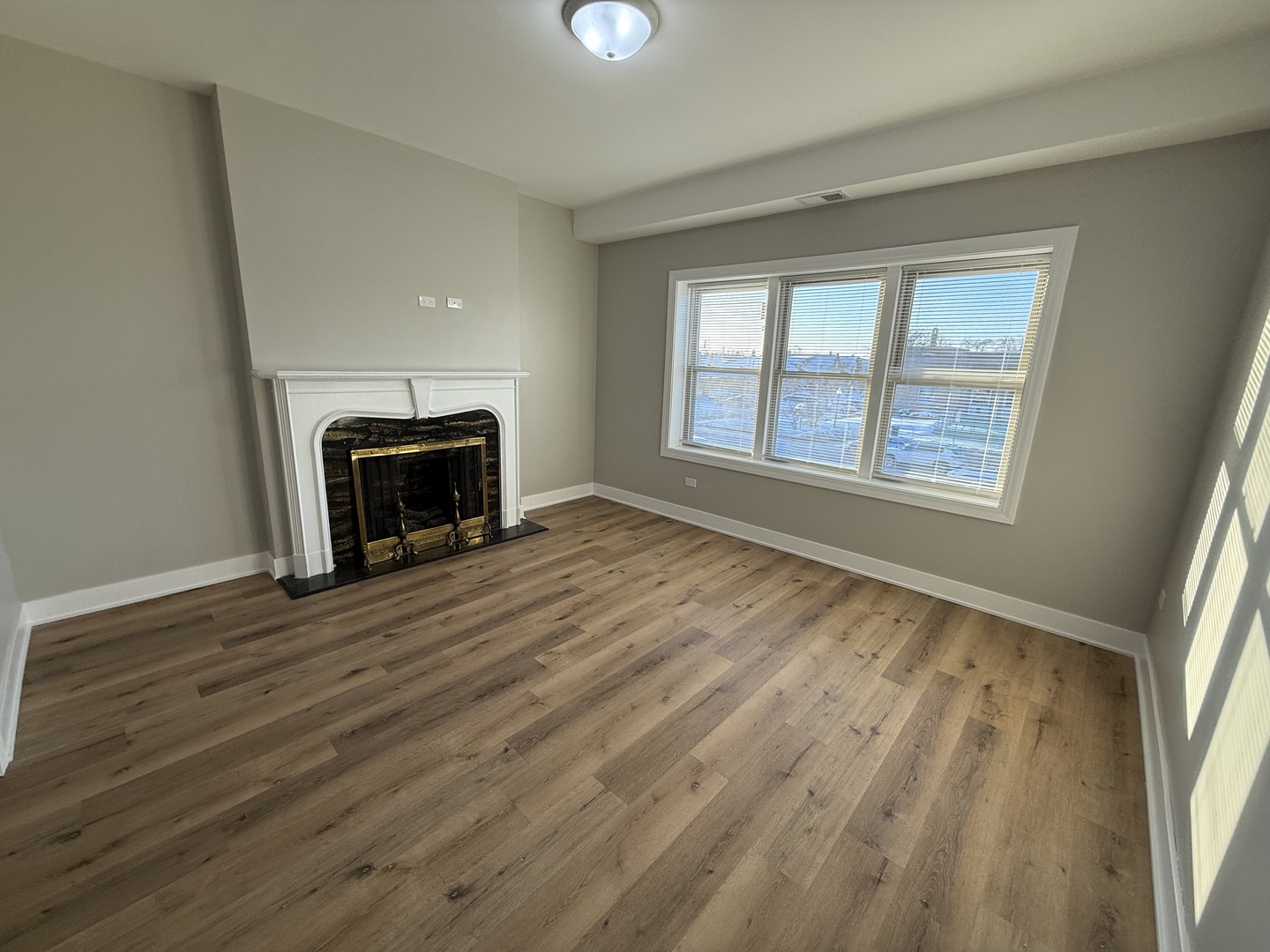 6634 Cermak Road, Unit 2 Berwyn, IL 60402 - Photo 2 of 20 a view of an empty room with wooden floor fireplace and a window