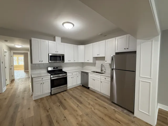 a kitchen with granite countertop white cabinets and stainless steel appliances