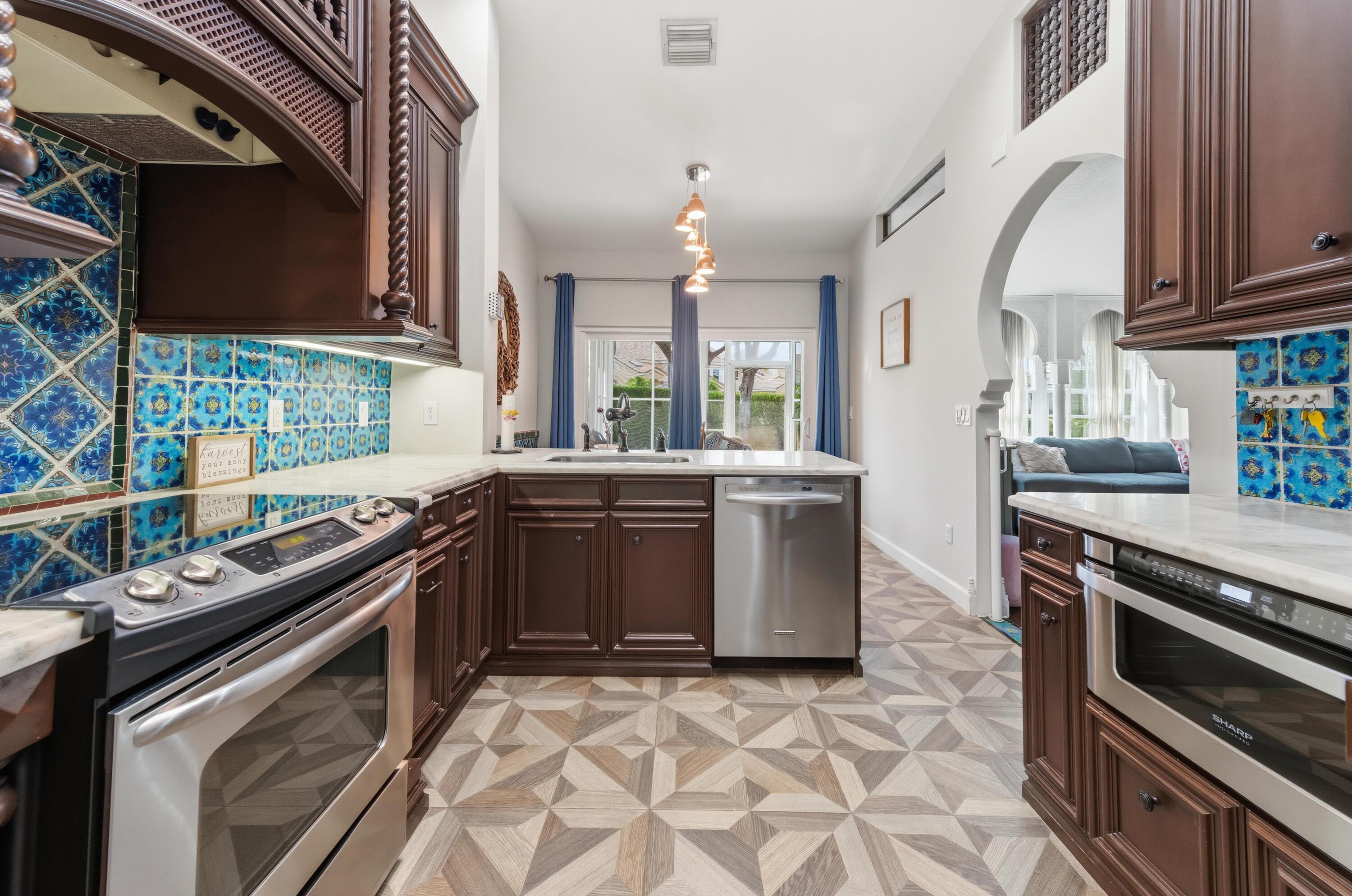 17221 Boca Club Boulevard, Unit 3 Boca Raton, FL 33487 - Photo 12 of 47 a kitchen with stainless steel appliances a sink stove and microwave