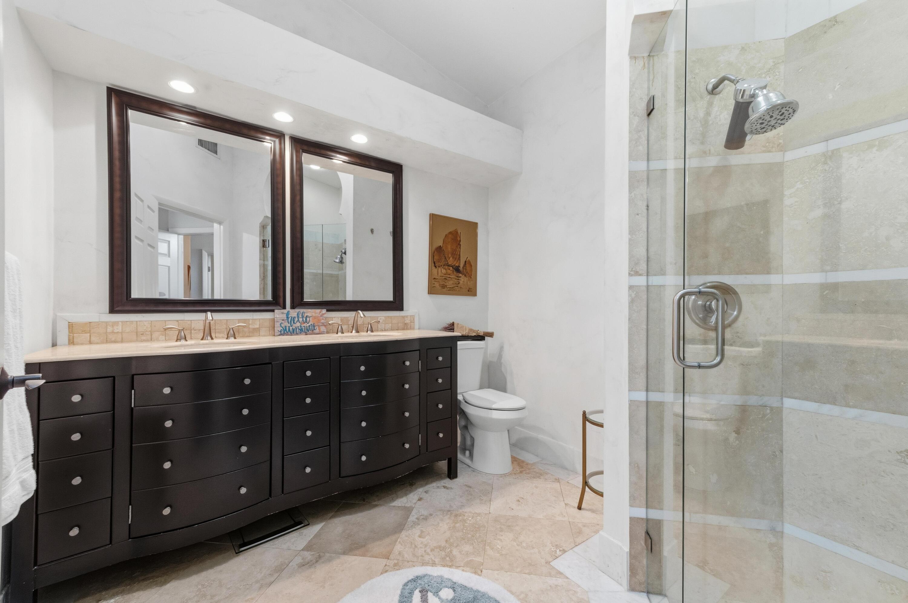 17221 Boca Club Boulevard, Unit 3 Boca Raton, FL 33487 - Photo 21 of 47 a bathroom with a double vanity sink toilet mirror and shower
