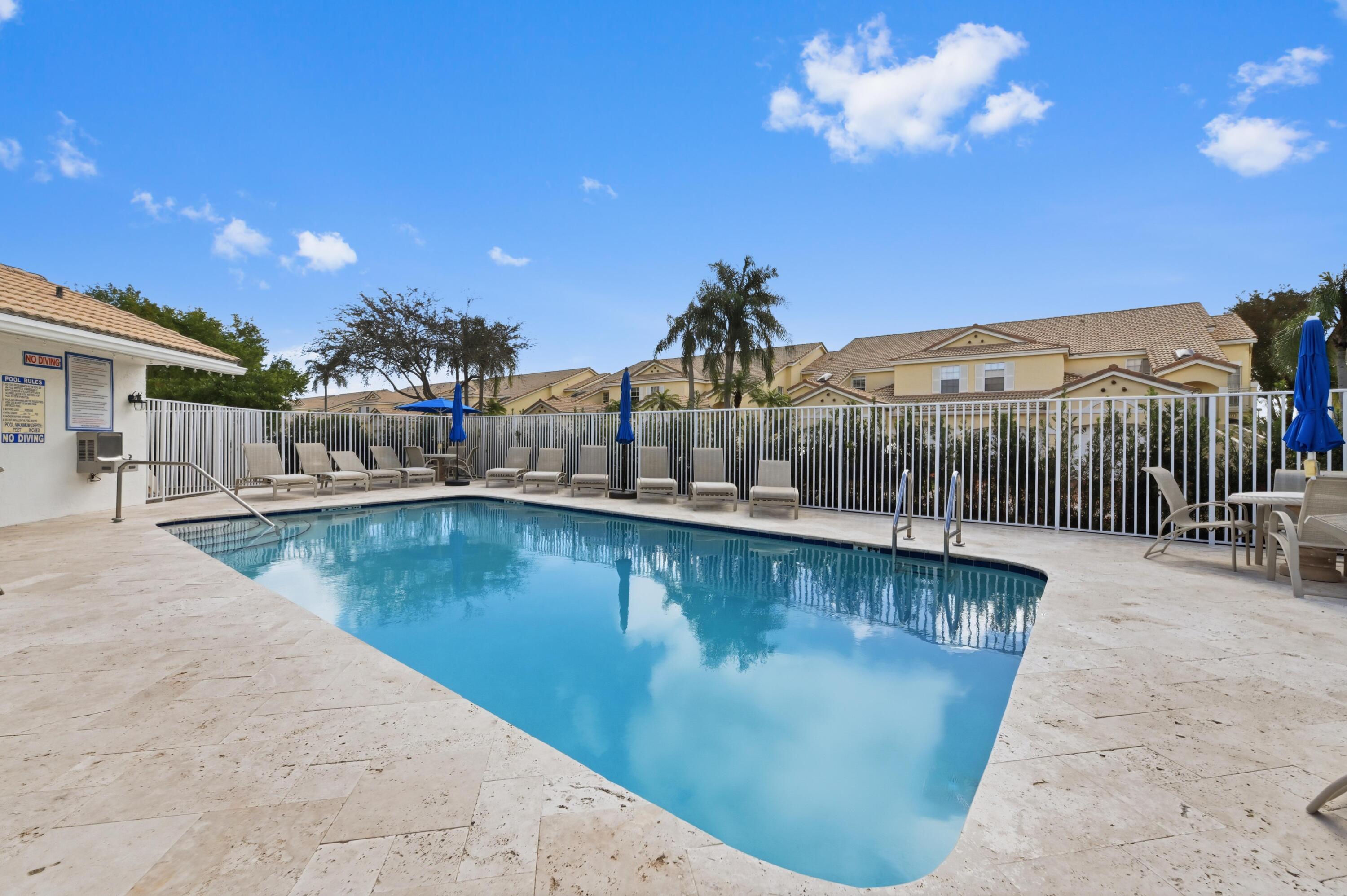 17221 Boca Club Boulevard, Unit 3 Boca Raton, FL 33487 - Photo 32 of 47 a view of a swimming pool with a patio and a yard