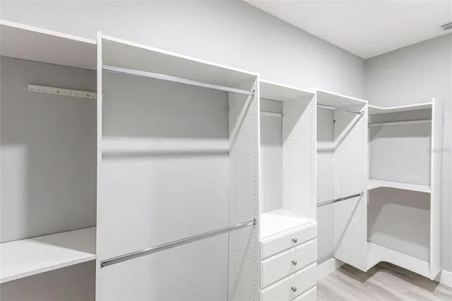 a view of walk in closet with empty racks