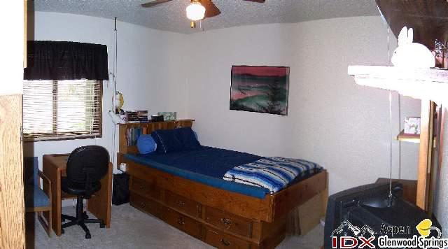 752 Cactus Court Rifle, CO 81650 - Photo 5 of 7 a bedroom with a bed and a chandelier