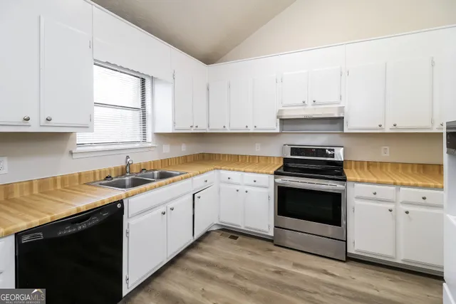 a kitchen with granite countertop white cabinets and white appliances