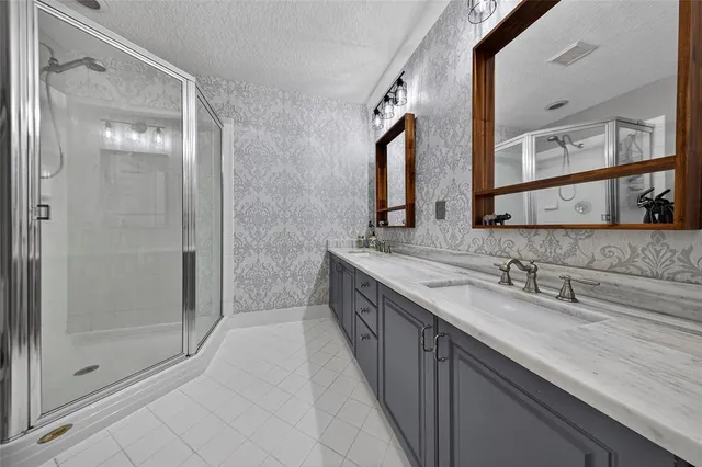 a spacious bathroom with a granite countertop sink mirror and shower