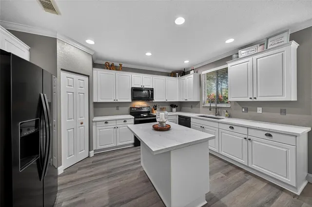 a kitchen with white cabinets stainless steel appliances and a window