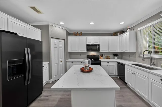 a kitchen with a sink stainless steel appliances and white cabinets