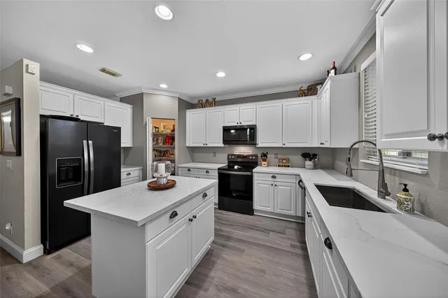 a kitchen with white cabinets and stainless steel appliances