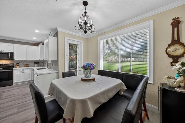a kitchen with a dining table chairs and refrigerator