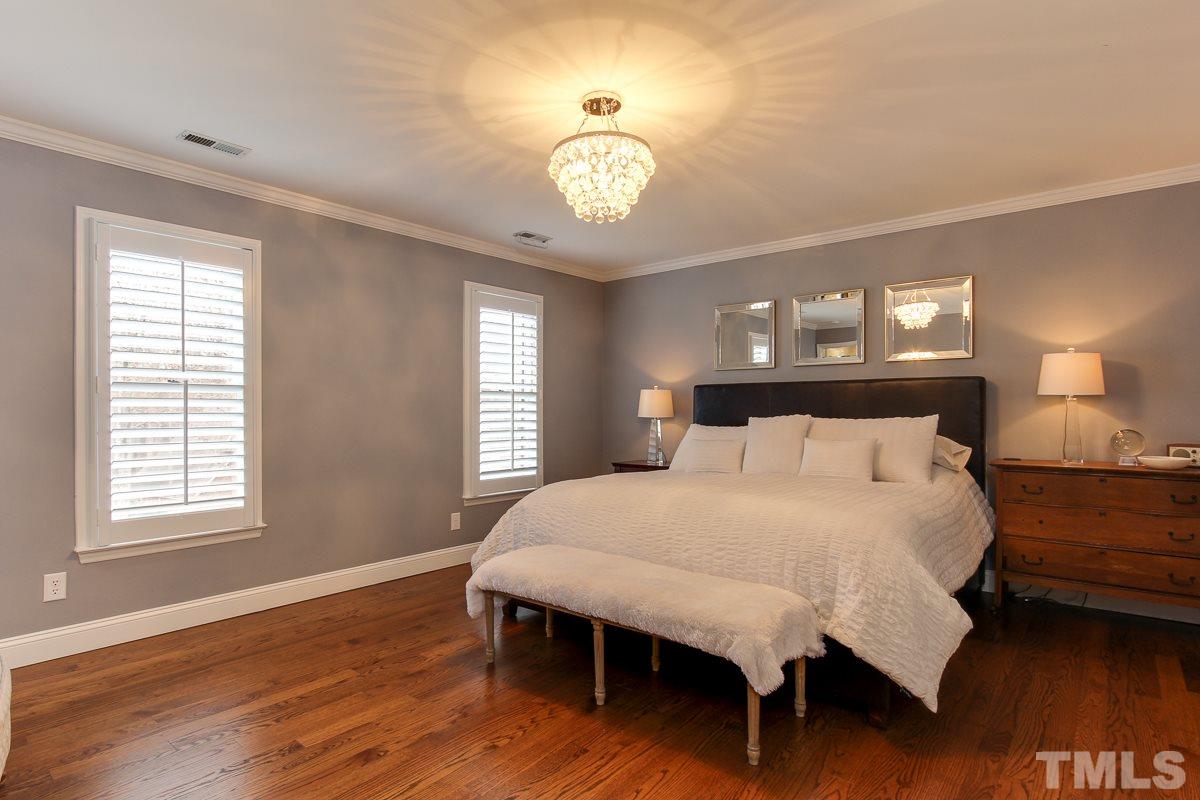 7904 Ogden Court Raleigh, NC 27613 - Photo 12 of 25 a bedroom with a bed and a chandelier