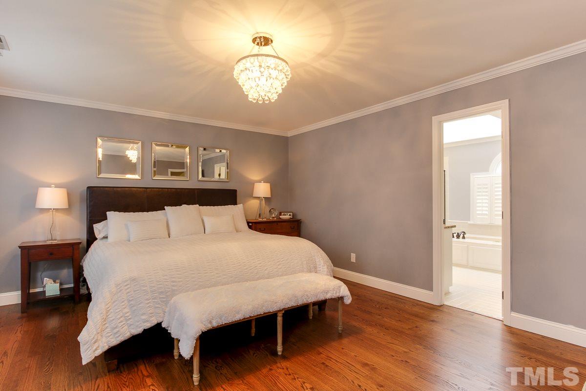 7904 Ogden Court Raleigh, NC 27613 - Photo 13 of 25 a large bed sitting in a bedroom and wooden floor