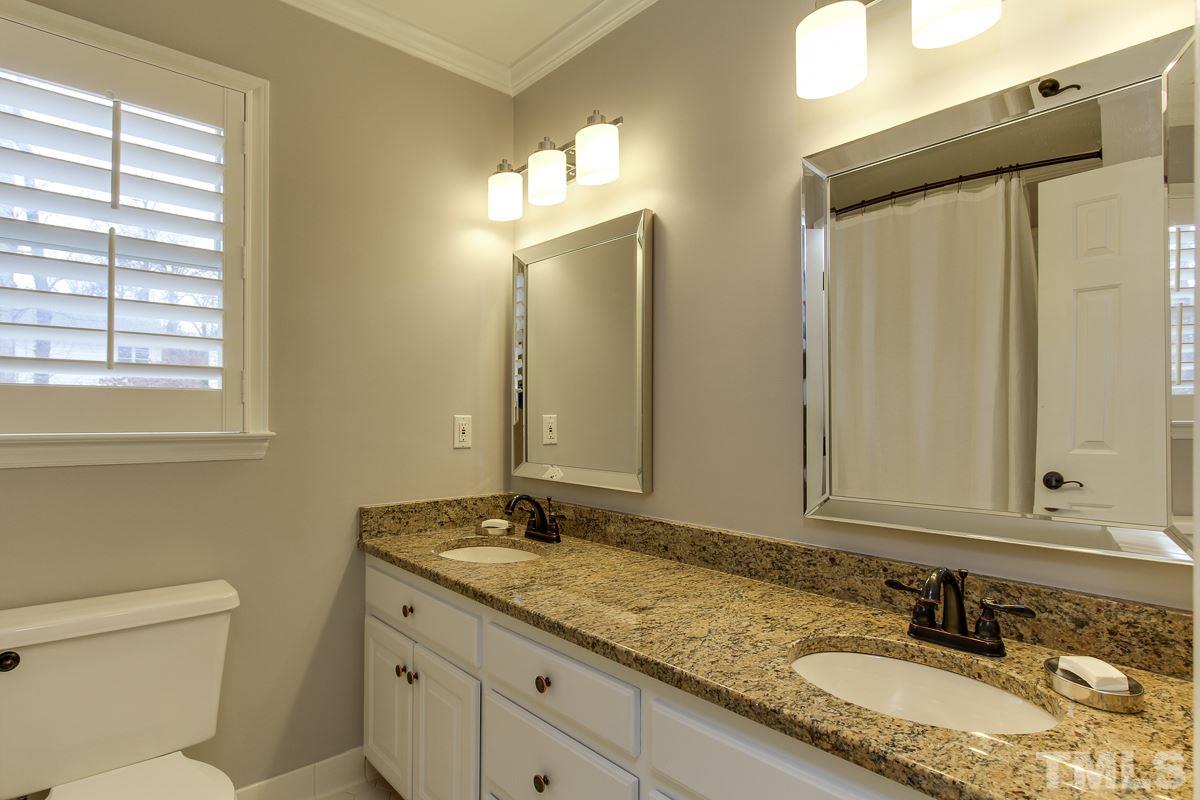 7904 Ogden Court Raleigh, NC 27613 - Photo 21 of 25 a bathroom with a granite countertop sink and a mirror