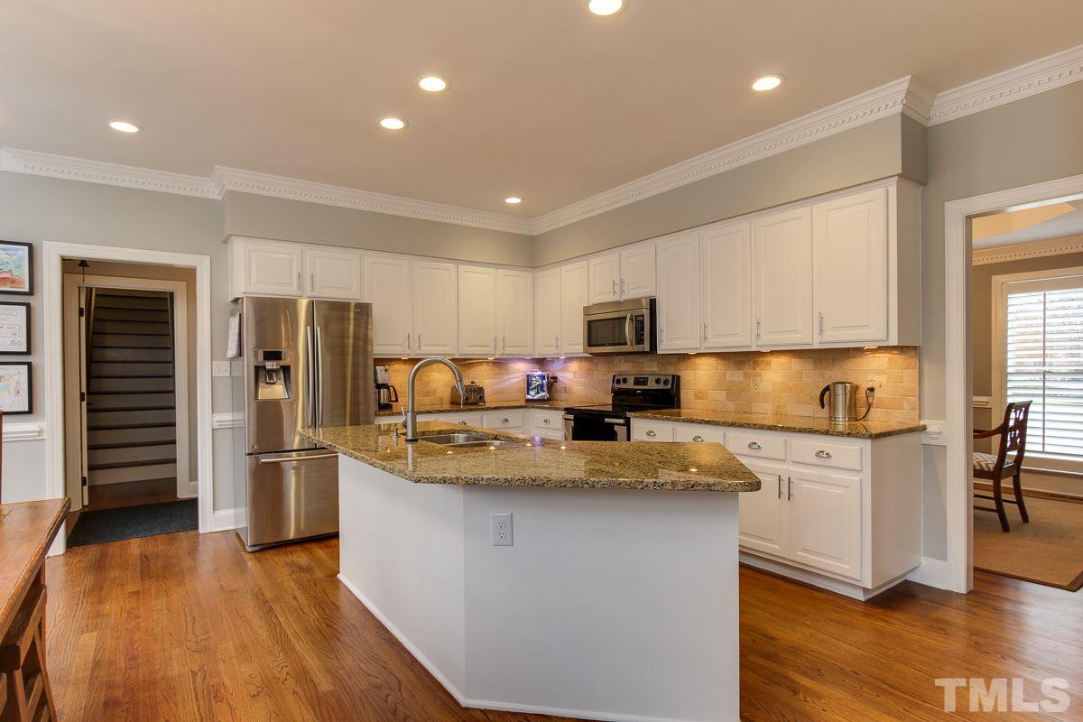 7904 Ogden Court Raleigh, NC 27613 - Photo 8 of 25 a kitchen with stainless steel appliances granite countertop a refrigerator a stove and a sink