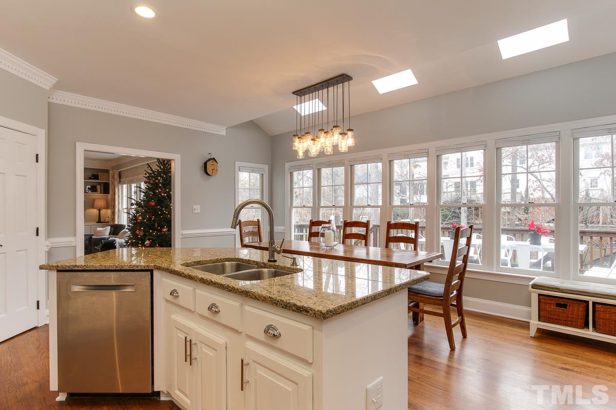 7904 Ogden Court Raleigh, NC 27613 - Photo 10 of 25 a kitchen with granite countertop a table chairs stove and wooden floor