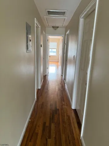 a view of a hallway with wooden floor and glass doors