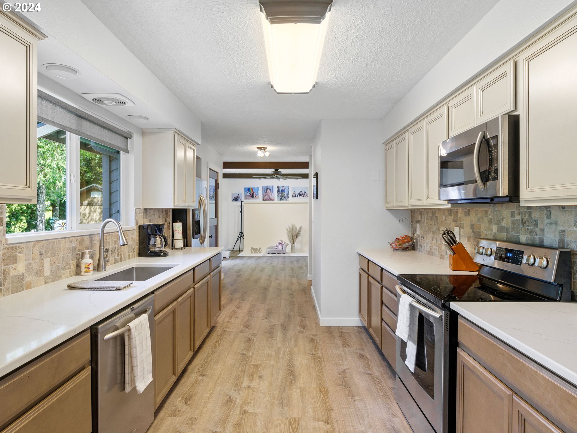 2551 Southeast Barnes Road Gresham, OR 97080 - Photo 11 of 38 a kitchen with kitchen island granite countertop a sink appliances cabinets and a large window