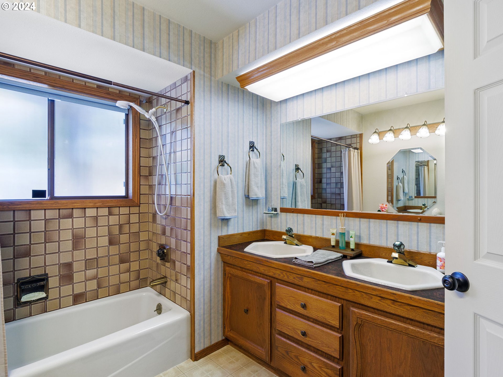 2551 Southeast Barnes Road Gresham, OR 97080 - Photo 20 of 38 a bathroom with a sink a large mirror and a bathtub
