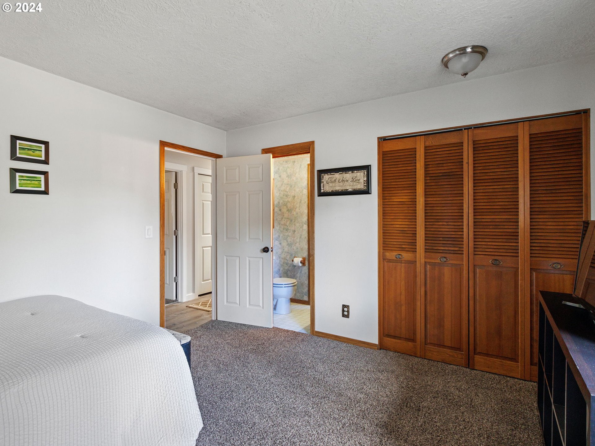 2551 Southeast Barnes Road Gresham, OR 97080 - Photo 25 of 38 a spacious bedroom with a bed and a cabinet