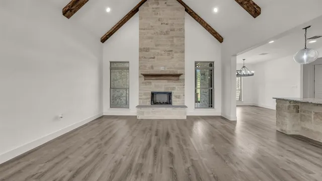 an empty room with wooden floor and fireplace