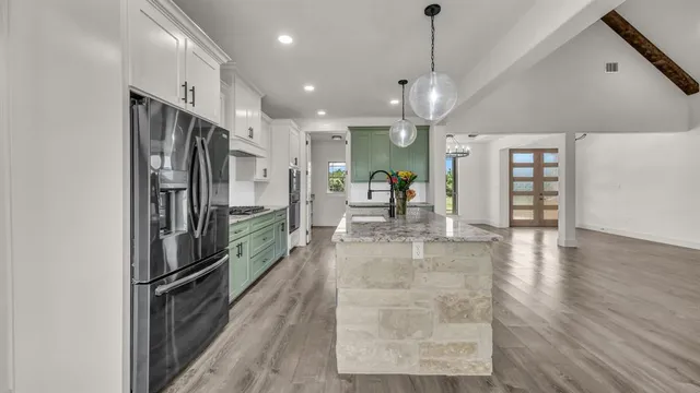 a view of a kitchen with refrigerator and wooden floor