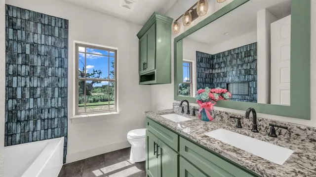 a bathroom with a granite countertop sink a mirror and a bathtub
