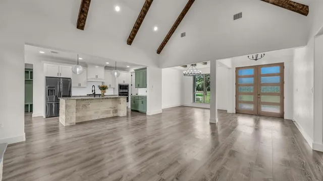 a view of a kitchen with refrigerator and wooden floor