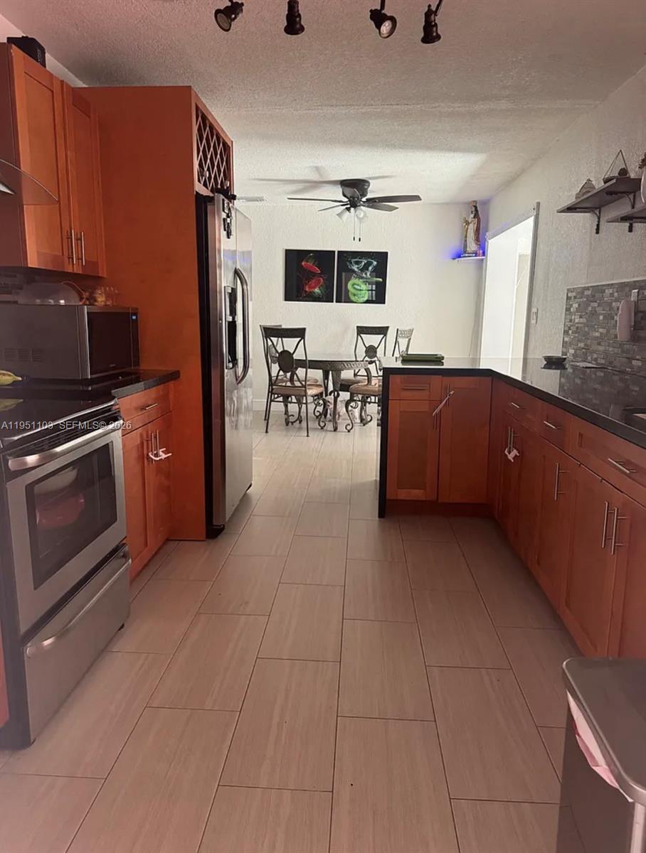 20530 Eagle Nest Road Cutler Bay, FL 33189 - Photo 3 of 17 a kitchen with stainless steel appliances granite countertop a refrigerator and a stove top oven
